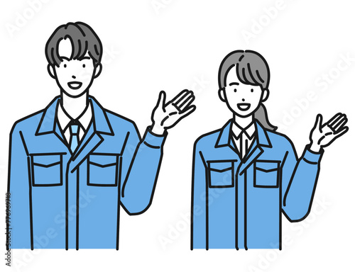 案内をする作業服姿の男性と女性（上半身）