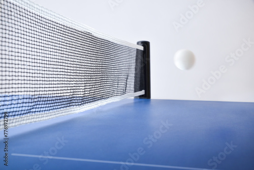 Ping-pong match concept with ball in motion on blue table