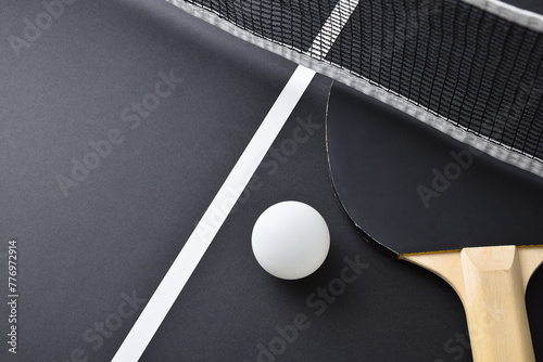 Detail of table tennis paddle and ball isolated on black