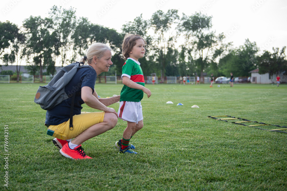 Mom with her son on the soccer field. A parent cares and encourages his child.