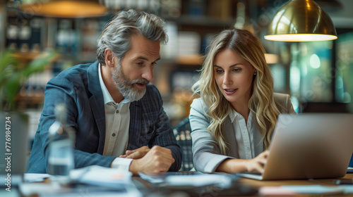 Male CEO and female partner discuss problem solving in office, while looking at laptops. Smart Businesspeople in Finance Work Together. Teamwork Concept.