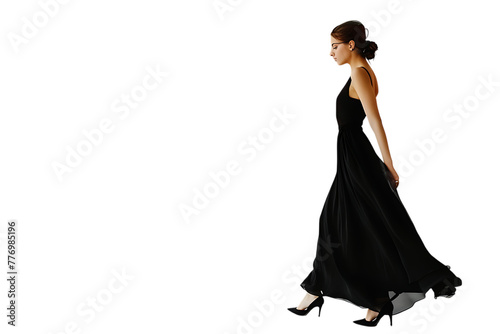 A figure dressed in black walks away against a white backdrop.






