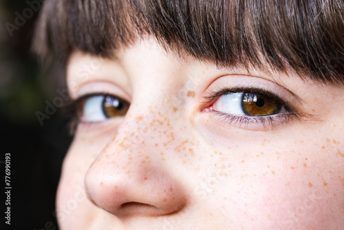 Close-up of child's freckled face with expressive eyes