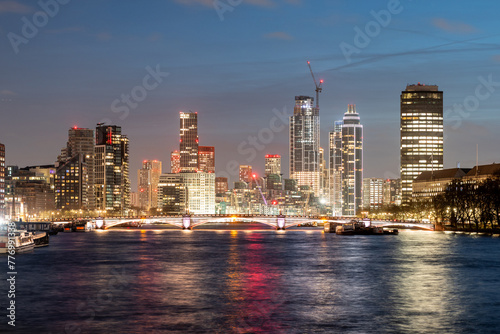 Panoramic view of London's skyline and thames river aglow with city lights at dusk