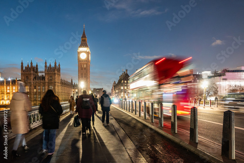 London street scene at night with red bus and Big Ben