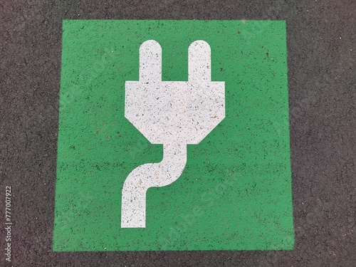 Green and white mark with plug on the ground of parking lot indicates electric charging station. Parking only when charging your car photo