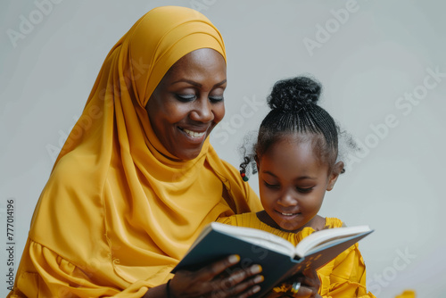 Covered grandmother in a yellow hijab reads to her granddaughter, African American family, warm, joyful moment conveying family and education themes