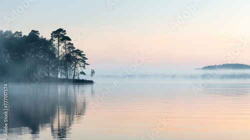 Tranquil dawn scene at a serene lake with fog delicately enveloping a forest on the shoreline photo