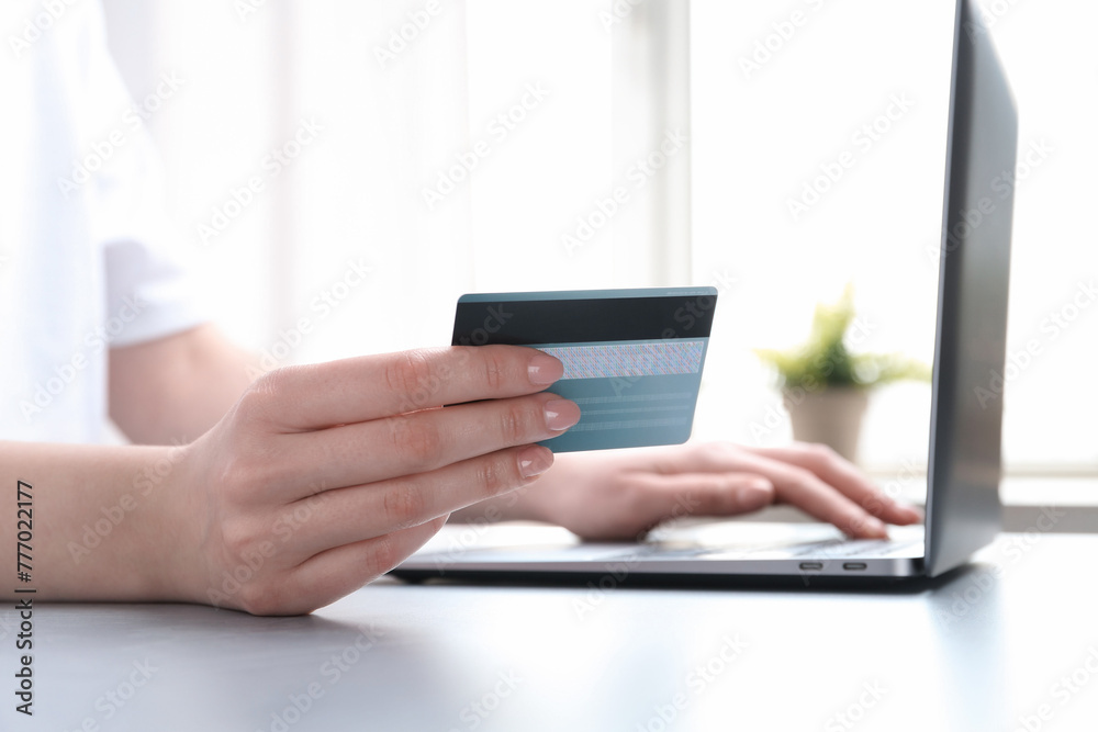 Online payment. Woman with laptop and credit card at white table, closeup Online payment. Woman with laptop and credit card at white table, closeup