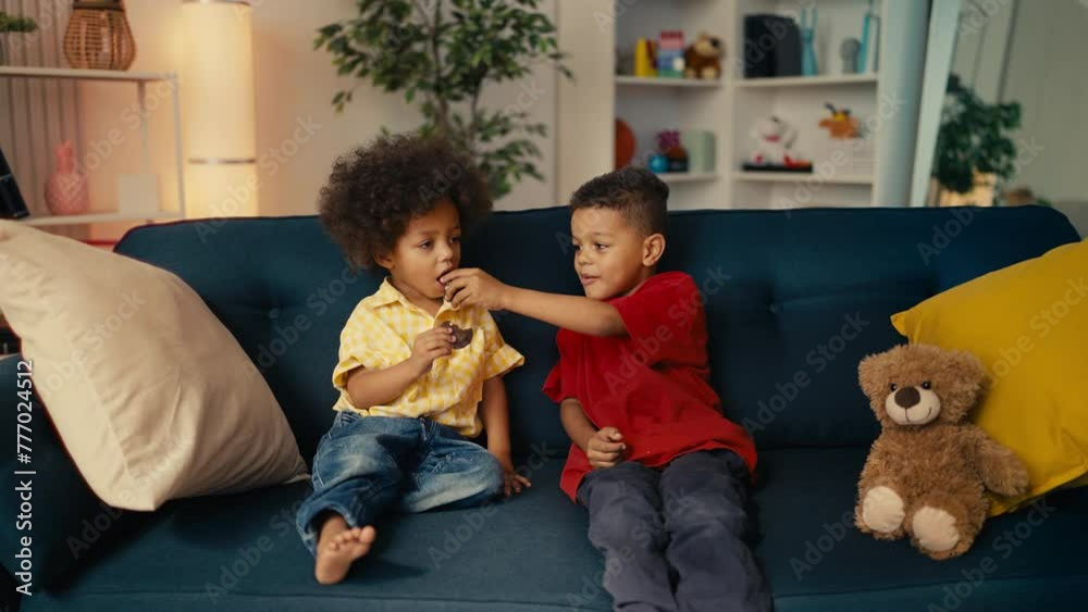 Little African American brothers sharing cookies with each other, trust and care Little African American brothers sharing cookies with each other, trust and care