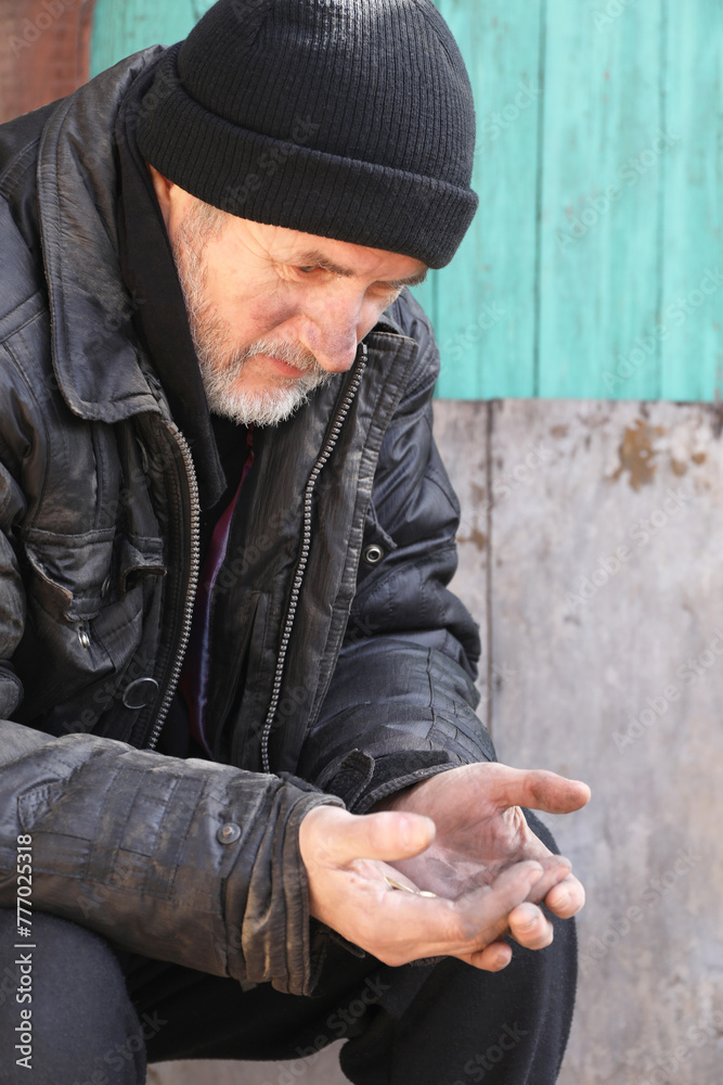 Poor homeless senior man holding coins outdoors Poor homeless senior man holding coins outdoors