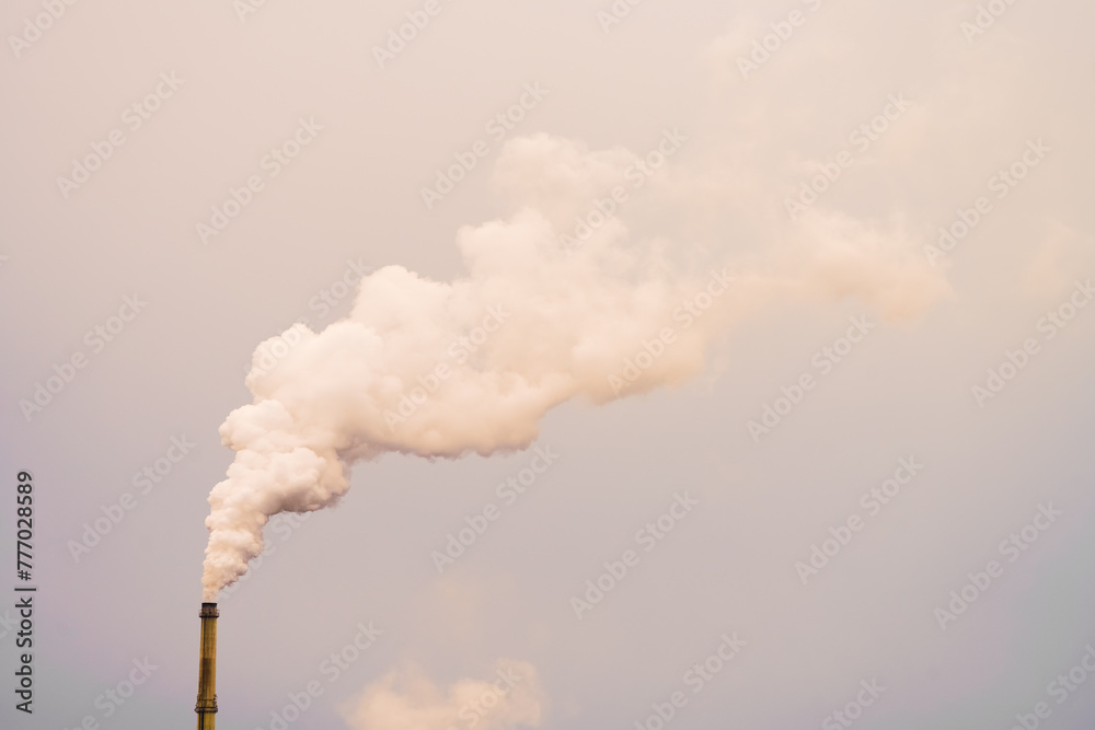 Cloud of smoke from a factory. Smoking chimney in the industrial area. Environment and pollution. Climate, global warming.
