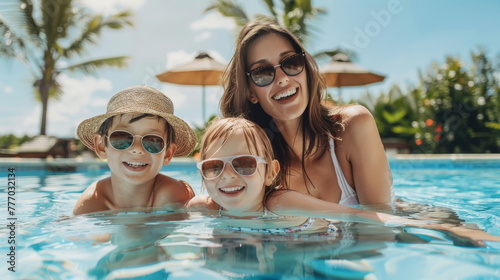 Happy mother and two children family at swimming pool during summer holidays travel