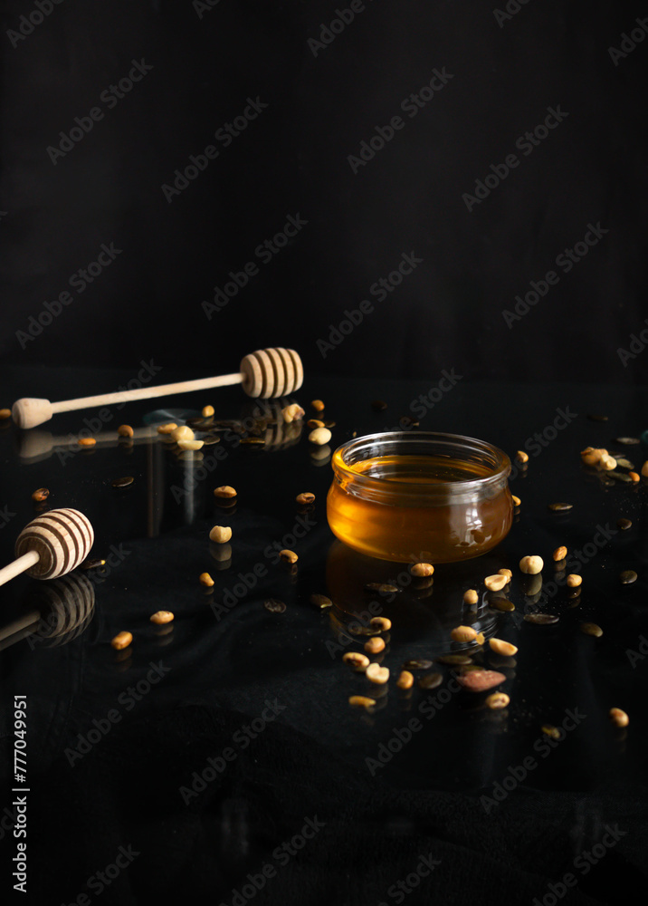 Fresh honey in a glass jar on a black background. Deliciously