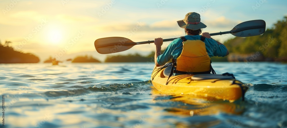 Fototapeta premium Man paddling kayak at sunset on sea kayaking and canoeing adventure in serene waters