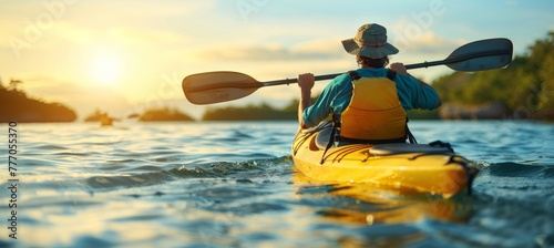 Man paddling kayak at sunset on sea kayaking and canoeing adventure in serene waters