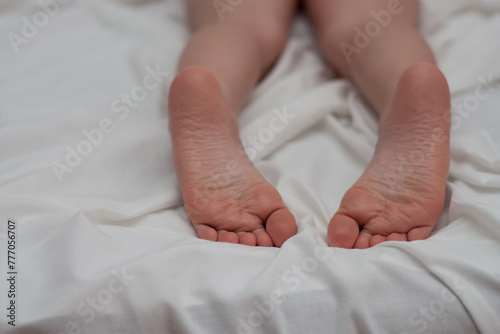 adobrable child feet sleeping in a comfortable bed, Focus on the foot. Barefoot. horizontal. copy space