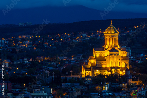 Night view of the historical district of Tbilisi from the mountain. Holy Trinity Cathedral of Tbilisi, Avlabari. Dark blue sky, orange lighting of the church. photo