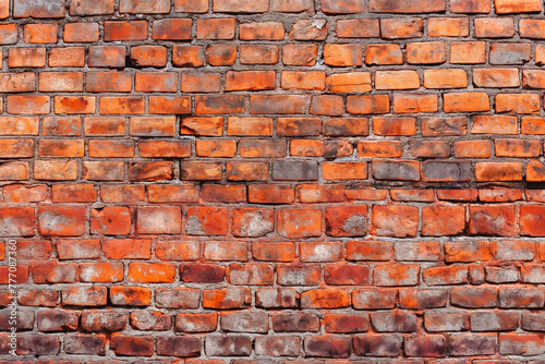 Old red brick wall background, wide panorama of masonry. Red brick laid in rows horizontally.