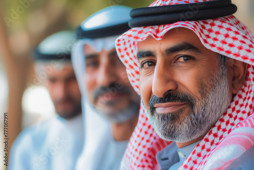 Portrait of Arab middle aged man wearing traditional while clothes with his business partners.