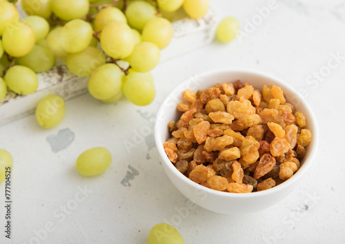 Green sweet dried raisins on light background with ripe grapes.