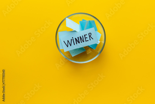 Winner concept. Lottery winner ticket in glass bowl full of paper sheets