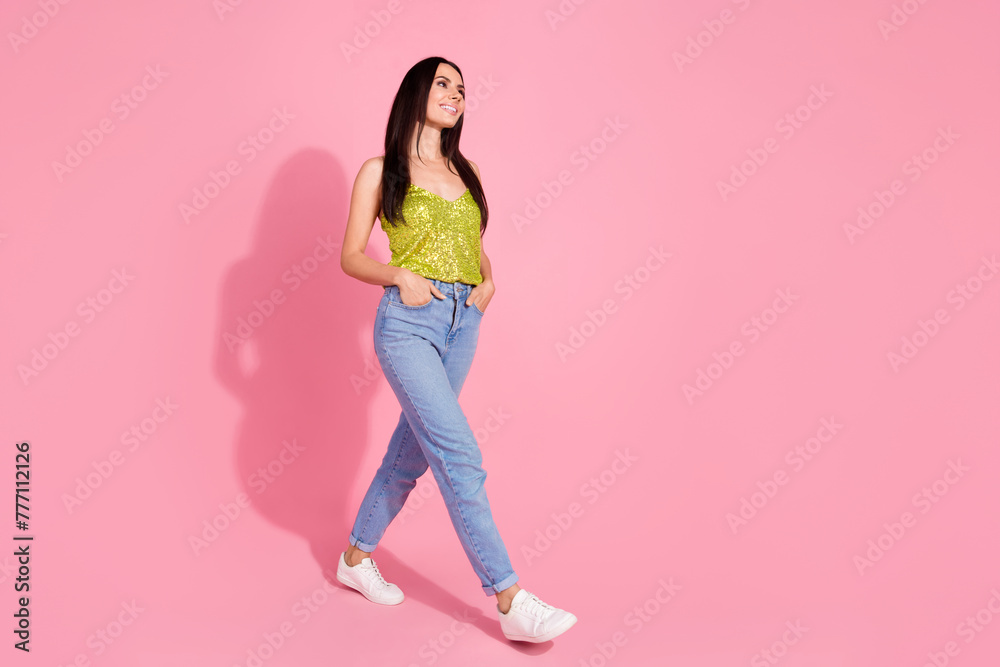 Photo of pretty nice positive girl wear stylish clothes walk look empty space isolated on pink color background