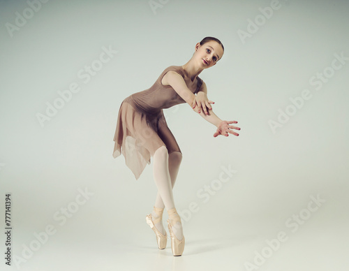 Fototapeta Naklejka Na Ścianę i Meble -  young teenage ballerina poses in a photo studio shows ballet and dance steps