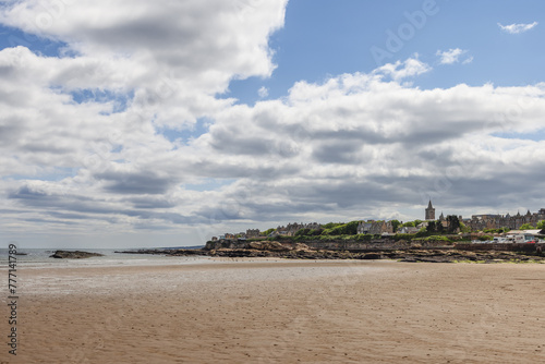 The serene beach of St Andrews, Scotland, sets the stage for a stunning view of the town historic skyline, marked by traditional buildings and a prominent church spire