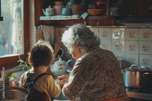 Grandma is cooking with her granddaughter in the kitchen. The warm moments between grandma and grandson in the kitchen. Senior life, happy family life photo