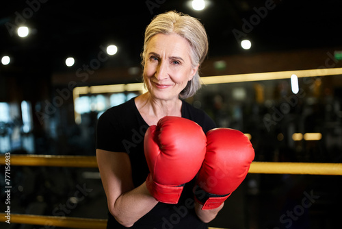 attractive joyful senior sportswoman with boxing gloves smiling at camera while on ring in gym © LIGHTFIELD STUDIOS