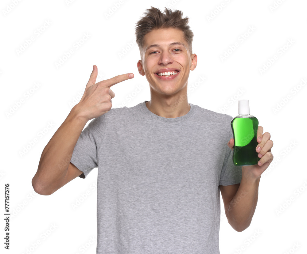 Young man with mouthwash pointing at his healthy teeth on white background Young man with mouthwash pointing at his healthy teeth on white background