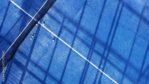 downward drone video footage on a blue paddle tennis court, sports courts concept