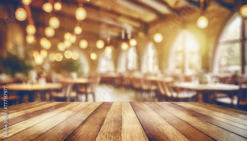 empty wood table top on blur light gold bokeh of cafe restaurant in dark background