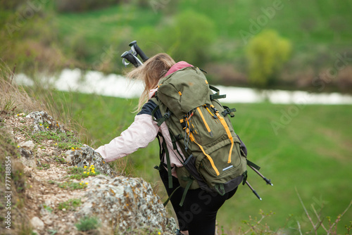 Young woman with backpack hiking in the mountains. Hiking concept. Trekking cliffs. Travel, traveler.