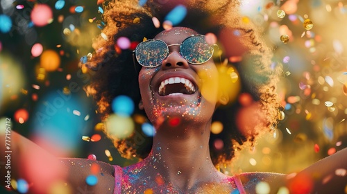 Happy black woman with confetti at party. Curly hair and a beautiful smile. Concept of celebration and fun.