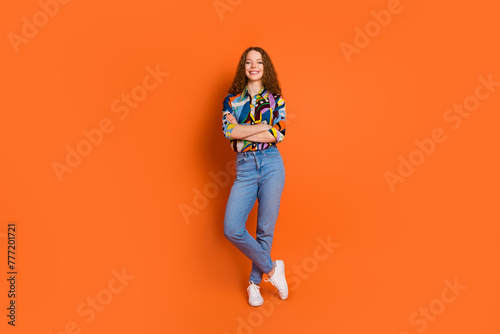 Photo of lovely pretty nice cheerful girl wear trendy clothes crossed arms empty space isolated on vivid orange color background © deagreez