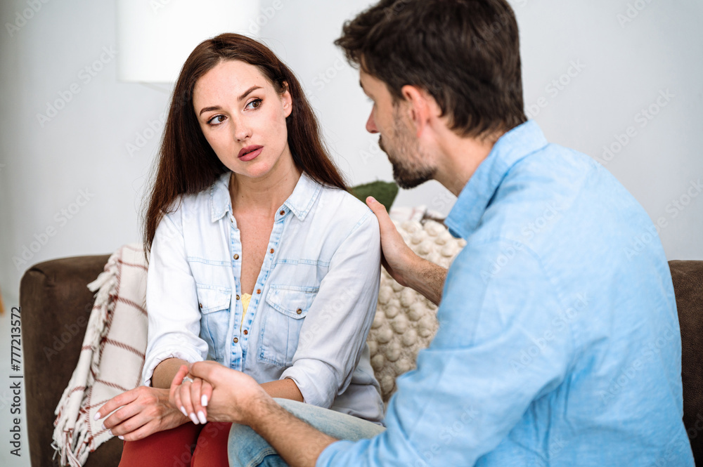 Fototapeta premium Young man giving support for woman, expressing empathy, hugging for shoulder