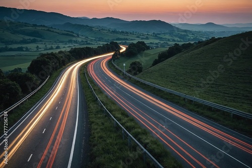 vehicle light trails stretching along country road at dusk