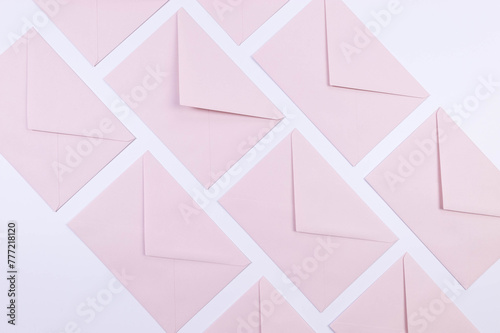 Top view of light pink envelopes on white background. Post flat lay. Copy space.