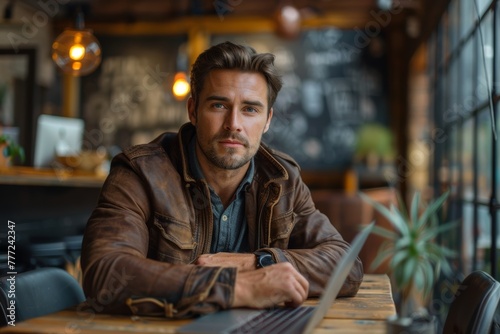 Portrait shot of a smiling professional businessman in neat suit outfits sitting at a desk using a laptop on a blurred modem office background. Generative AI.