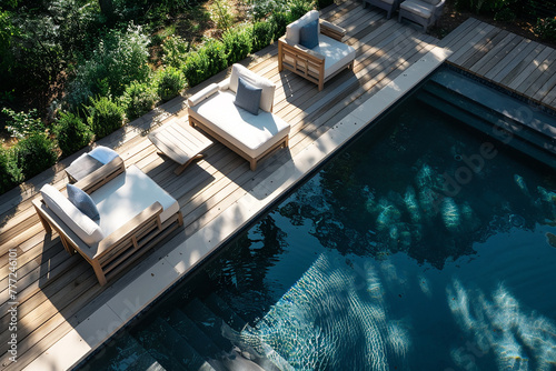 Comfortable patio furniture arranged on a deck next to a refreshing swimming pool.