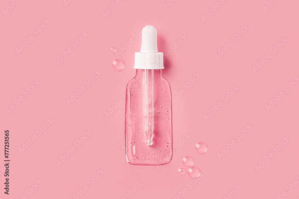 Cosmetic jar with a dropper in the form of a transparent gel spilled  on a pink background.