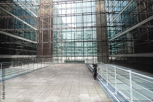 skyscraper inside: light courtyard with a parked bicycle; view of the modern business district outside the large windows (La Défense, Paris, France)