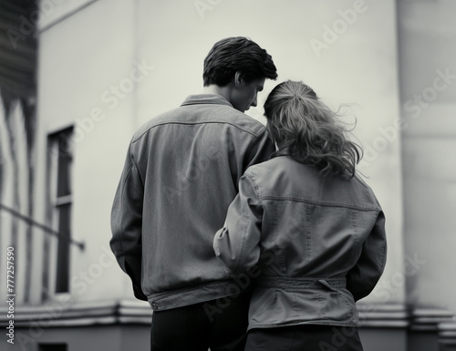 Young hugging couple in casual clothes, man and woman, rear view, against the background of an old building. Black and white Photography in retro style. AI generated. © Ekaterina