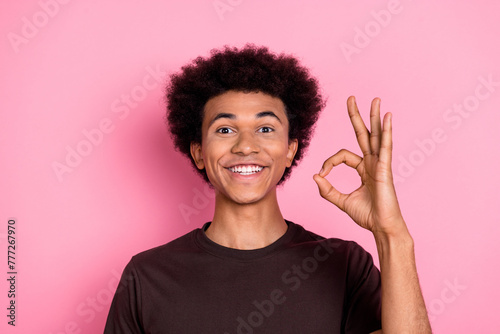 Portrait of cheerful wavy hair man american student gesture okey symbol good job done in university isolated on pink color background