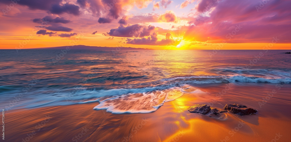 sunset over the beach in Hawaii, with rocks and sand visible on both sides of the water's edge. The sky is painted with hues of orange, pink, purple, yellow, and blue