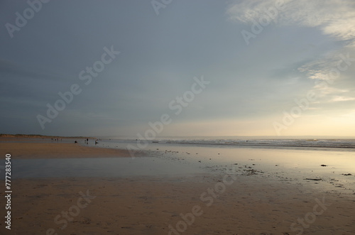 Peaceful England beach with a mix of sand, clouds and sea in pastel hues.