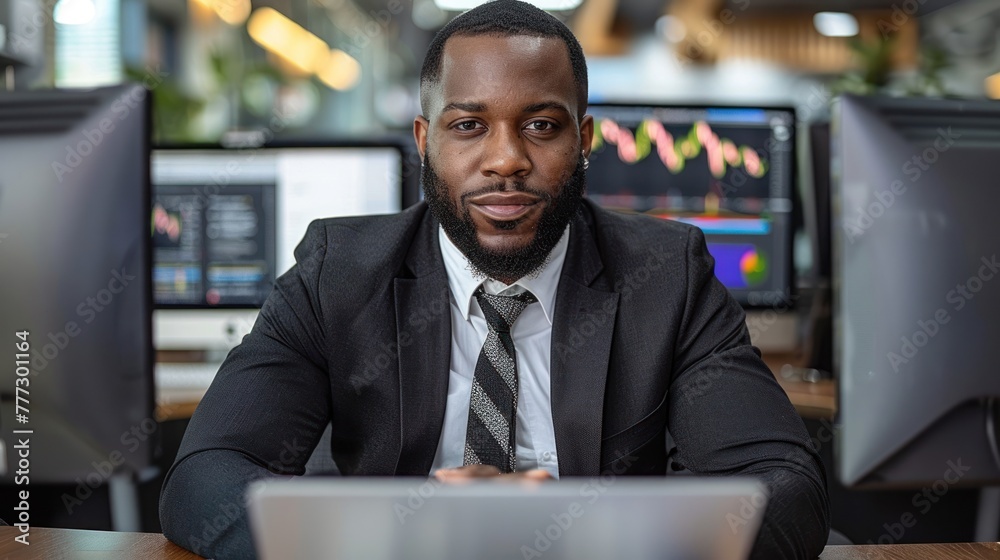 A man working at a desk with two computer monitors in front of him A man working at a desk with two computer monitors in front of him
