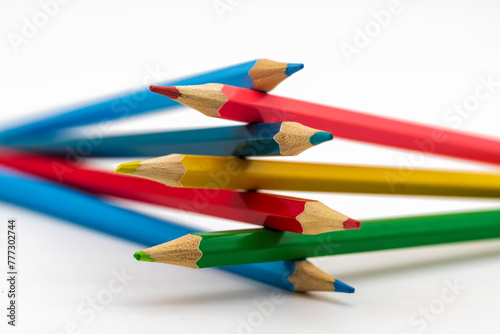 Lápices de colores entrelazados apilados, aislado en blanco